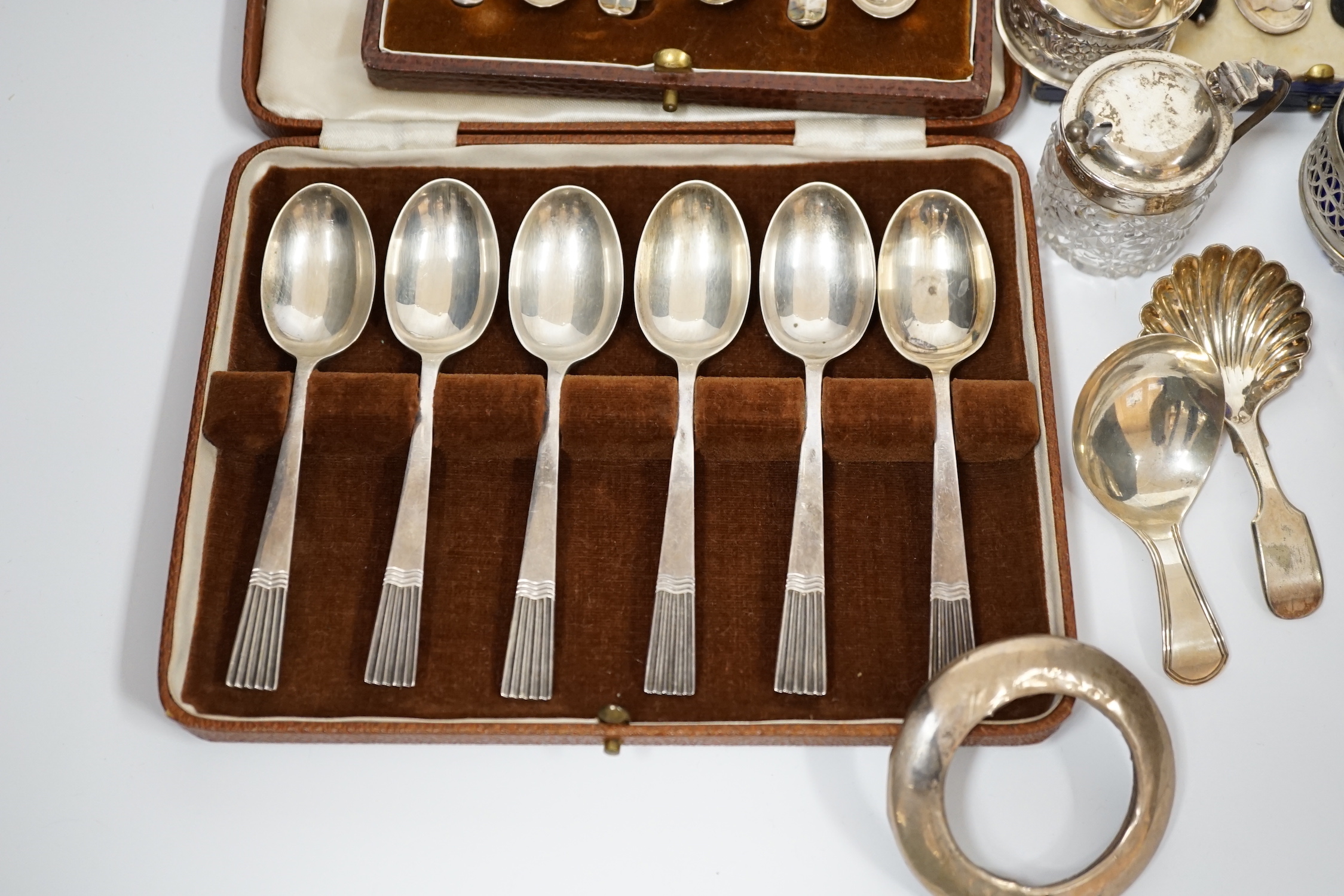 A white metal pepperette modelled as barrel and other silver and plated items including a Georgian caddy spoon, condiments, three cased sets of silver spoons, etc.